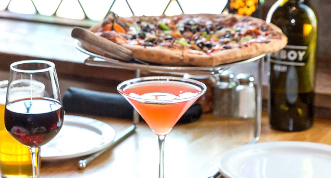 Pizza with red wine and cocktail in martini glass.