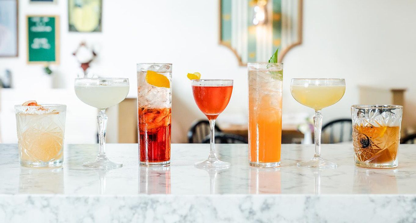 7 various cocktails on a marble counter.